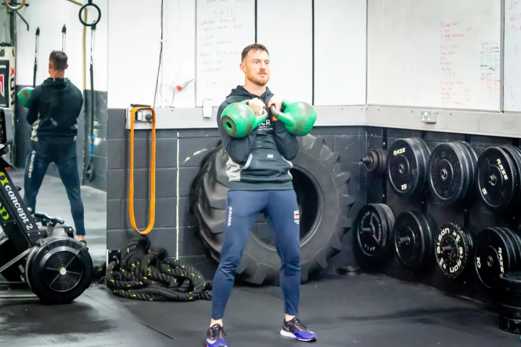 Double kettlebell clean rack position with elbows in and core braced