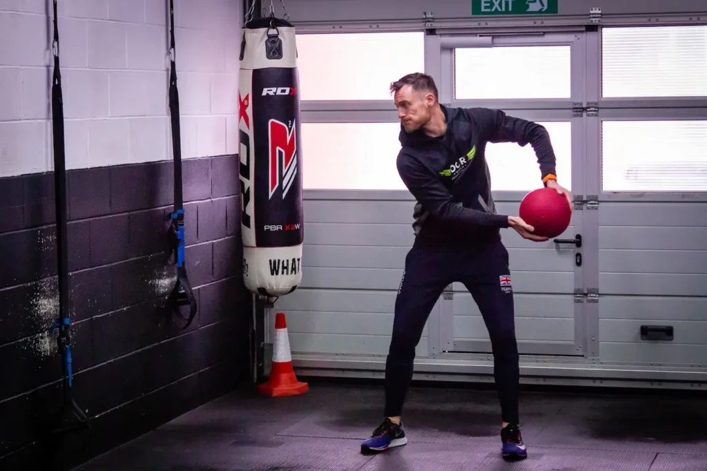 Athlete rotating torso and hips while holding a medicine ball before release